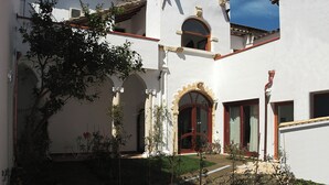 A traditional building with a courtyard, arched doorways, and a tiled roof.