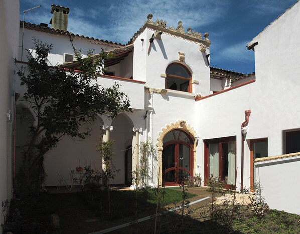 A traditional building with a courtyard, arched doorways, and a tiled roof.