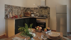 A kitchen with a tiled backsplash, a stove, oven, and a refrigerator.