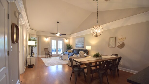 A spacious living room with a dining area, a ceiling fan, and a large window. - Cozy 2-bedroom condo in charming Townsend with WiFi, AC (Townsend)