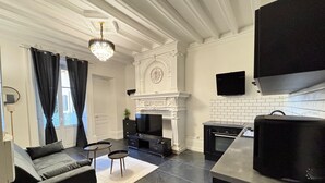 Un salon moderne doté d’une cheminée, d’un téléviseur et d’un coin cuisine avec un four à micro-ondes.