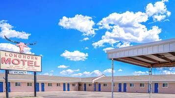 Un motel bajo un cielo azul despejado y nubes esponjosas.