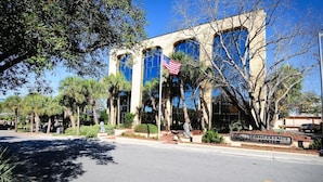 A building with a large glass facade, a flag, and a sign that reads "Conference Center." - Hotel O Sunset Waves Myrtle Beach, Sc (Myrtle Beach)