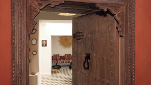 Une porte en bois au style rustique, portant le numéro « 106 », et une petite table ronde avec une chaise dans la pièce.