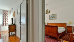 A bedroom with a wooden bed, a chandelier, and a rug. - Apartment RuzicaCharming 1-bedroom apartment with Sveti Stefan (sveti stefan)