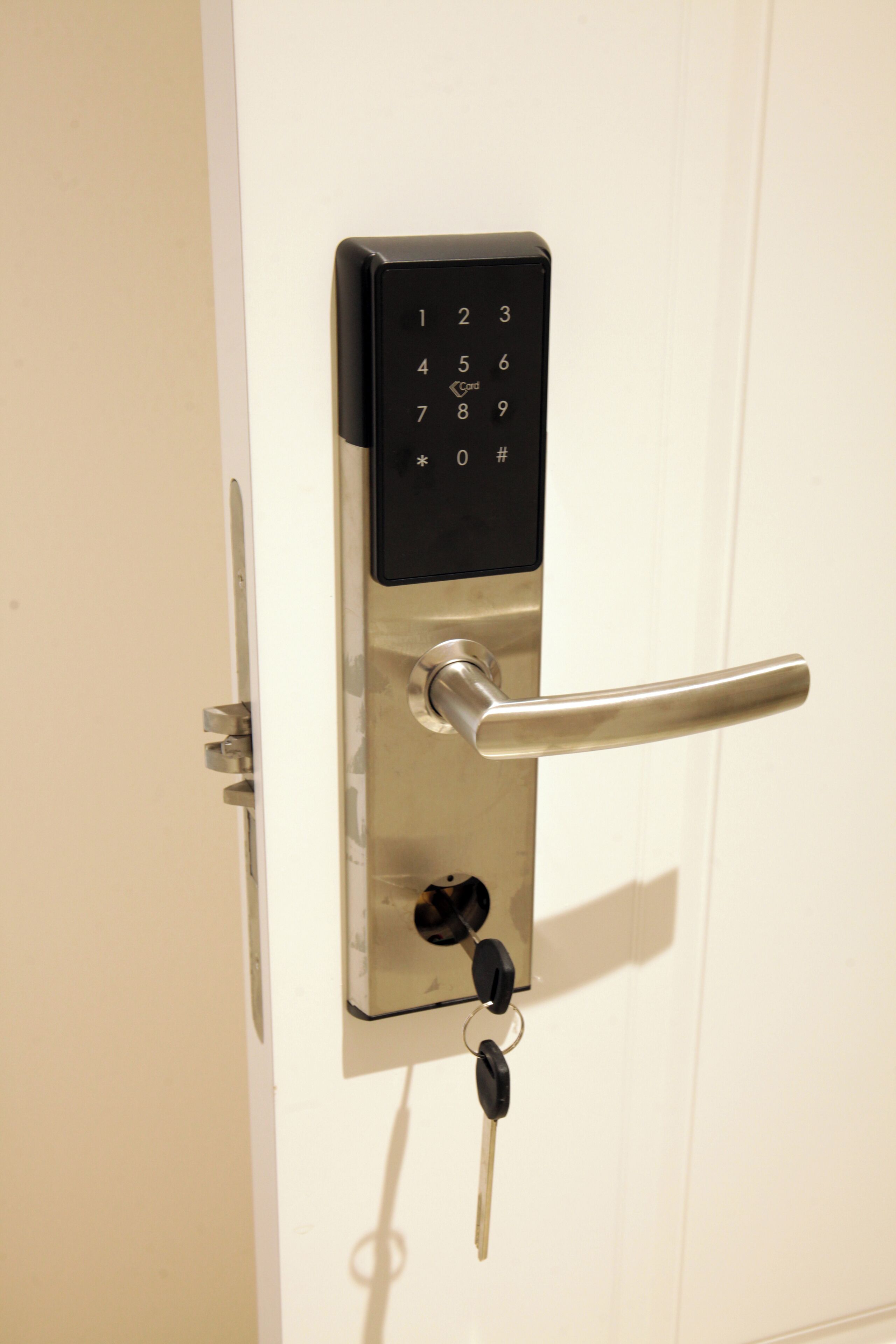 Une porte dotée d’un verrou à clavier numérique et d’une clé insérée dans la serrure.