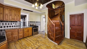 Eine Küche mit Holzausstattung, einem eingebauten Backofen und einem Boden mit Steinmuster.
