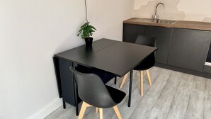 Een moderne keuken met een zwart aanrecht, een spoelbak en een potplant.