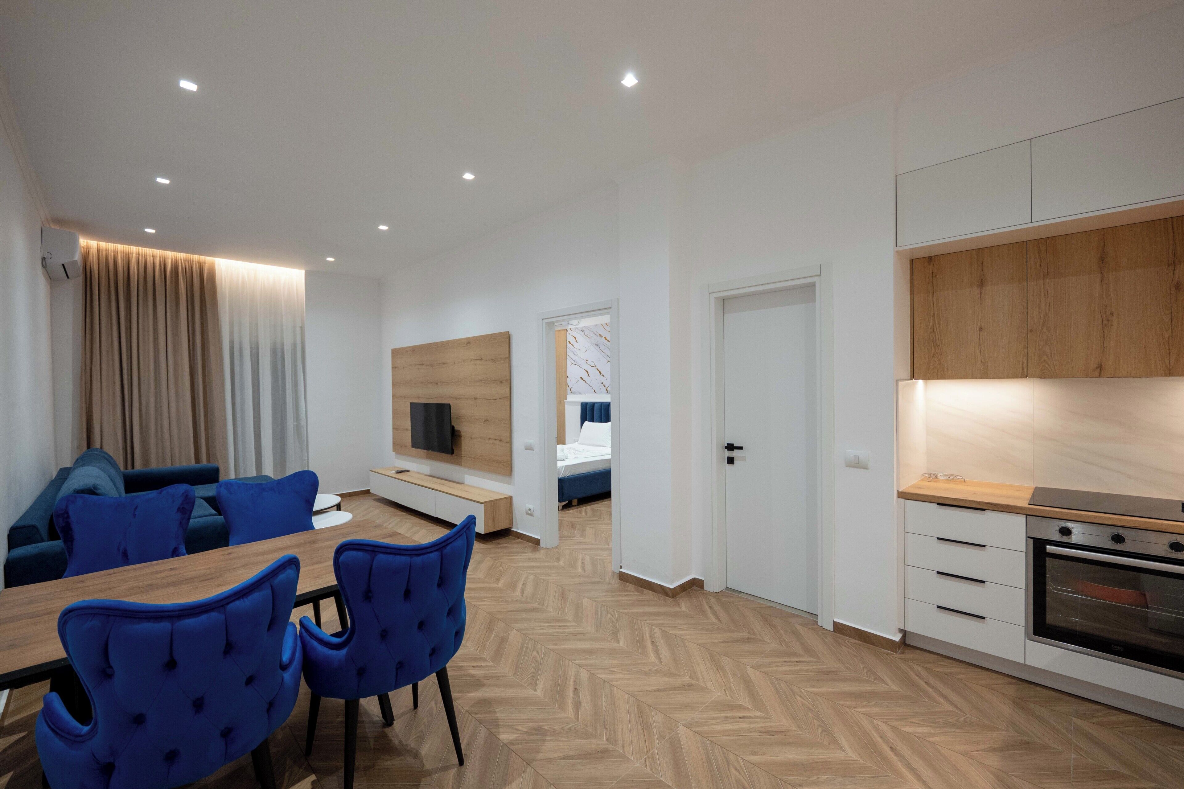 Ett modernt hotellrum med en matplats, ett litet kök och ett sovrum.