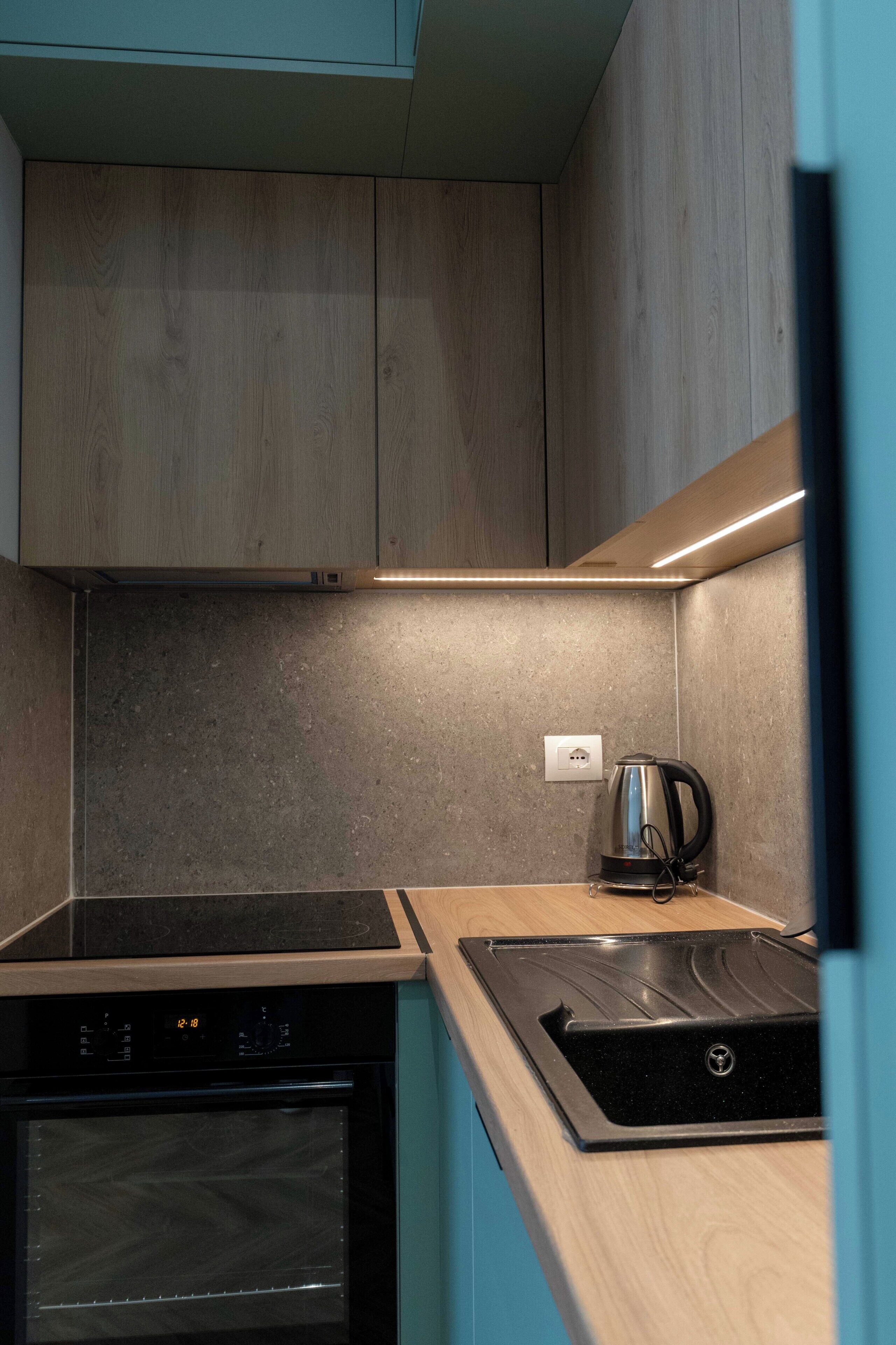 A kitchen with wooden cabinets, a built-in oven, and a coffee maker.