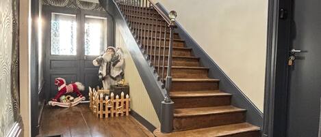 A wooden staircase with a metal railing leading to a landing.