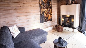A cozy room with a fireplace, a sofa, and a wall-mounted painting of a deer.