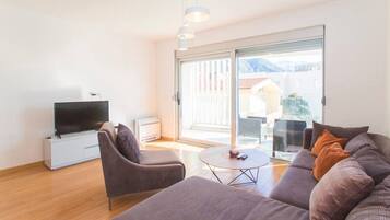 Deluxe appartement, gedeeltelijk uitzicht op zee | Woonkamer