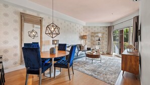 A modern living room with a dining area, a sofa, and a coffee table. - Hot Tub + Pool | 2 Bed 2 Bath Ground Suite (West Kelowna)