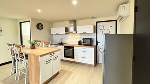 Een moderne keuken met witte kasten, een houten eiland en een ingebouwde magnetron.