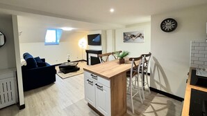 Een modern appartement met keuken, eethoek en zithoek.