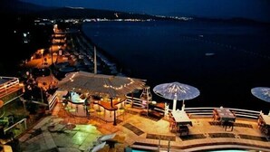 A poolside area with lounge chairs and umbrellas, overlooking a body of water. - portofino hotel (Bodrum)