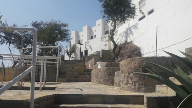 A stone staircase leading up to a white building with a metal railing. - portofino hotel (Bodrum)