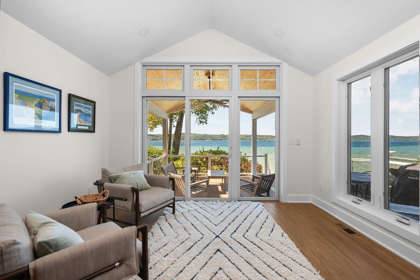 A spacious living room with a large sliding glass door leading to an outdoor patio with a view of the water.
