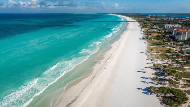 A coastal hotel with a beach view, a long sandy shoreline, and a clear blue sea. - Sports & Beach Hub! 2BR/3-Beds Near IMG, Premier Campus & AMI! (Bradenton)