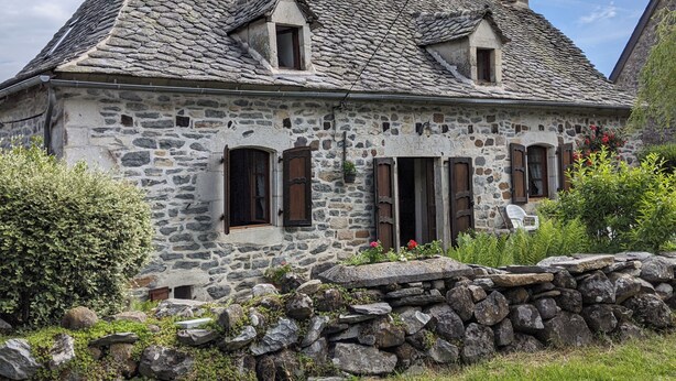 A stone house with a steeply pitched roof, two small dormer windows, and a chimney. - My grandfather's house (Valette)