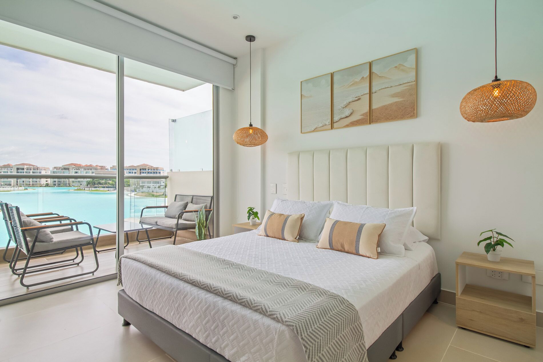 Un dormitorio moderno con una cama grande, vistas a una piscina y un balcón con una silla.
