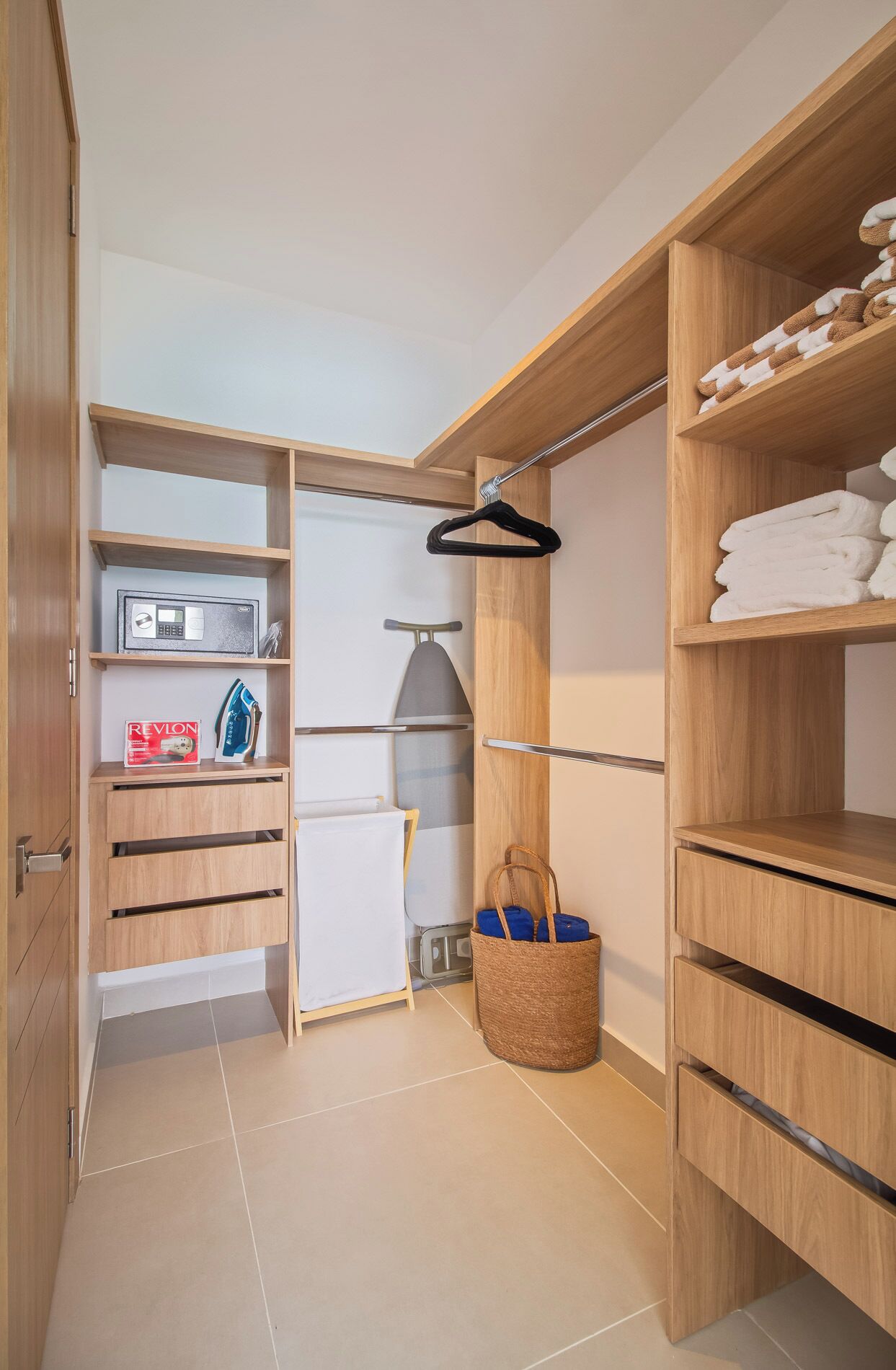 A walk-in closet with wooden shelving, a hanging rack, and a basket.