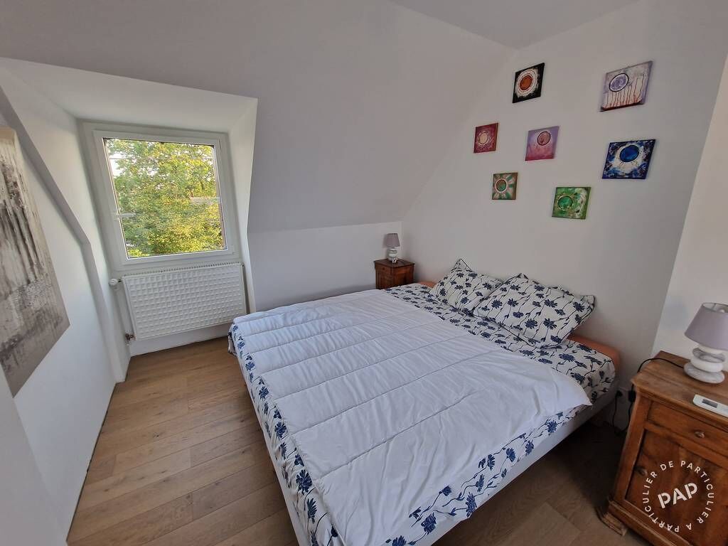 A bedroom with a bed, a window, and a radiator.