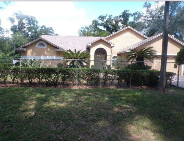 A two-story house with a fenced yard, a covered patio, and a small garden area. - 3/3 home in Thonotosassa.Near Amphitheater, Hard Rock,USF, Busch Gard, MOSITampa (Thonotosassa)