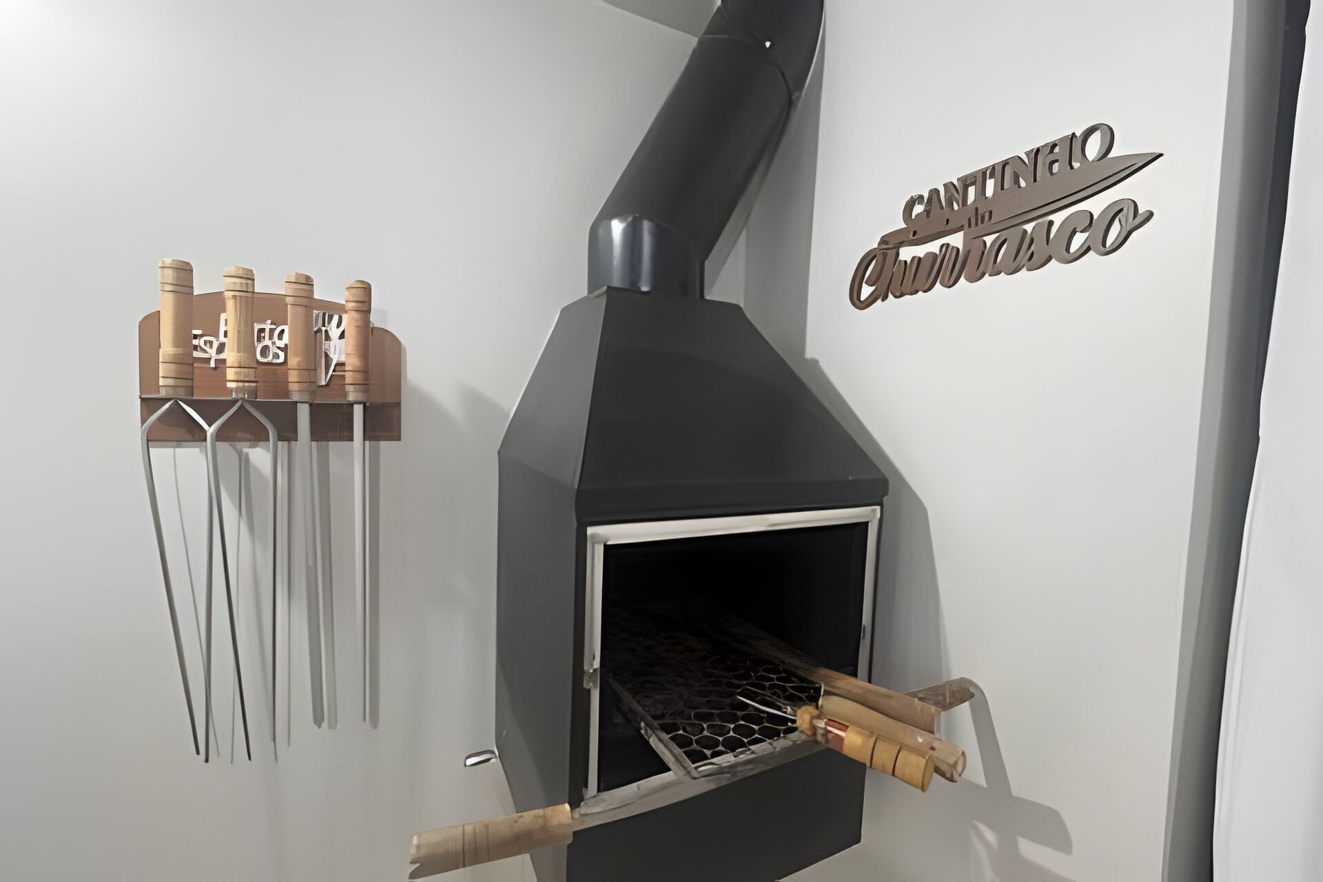 A modern kitchen with a built-in oven, a hanging rack with kitchen utensils, and a wall-mounted sign.
