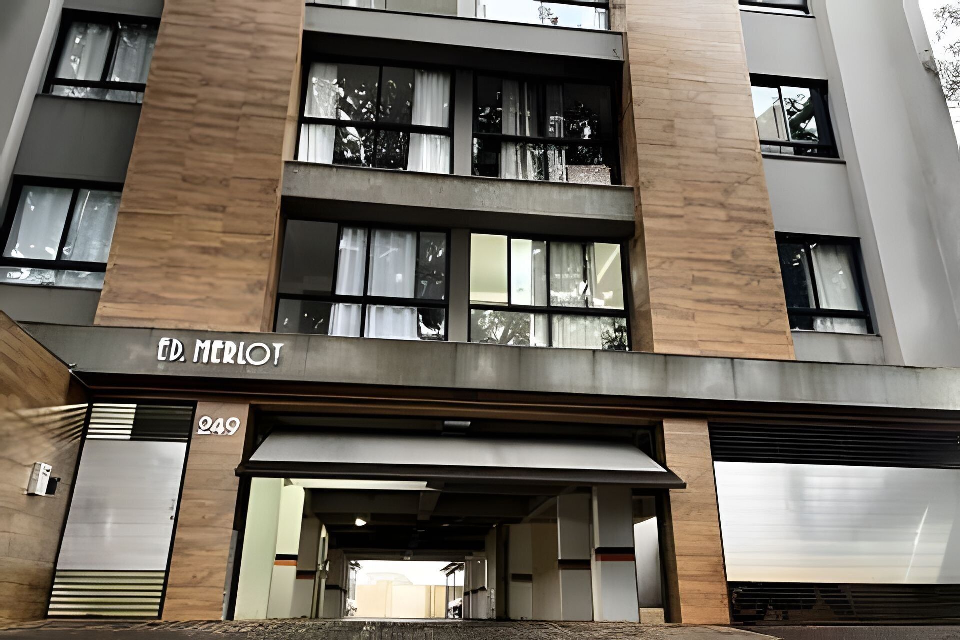 A modern building with a sign reading 'ED. MERLOT' and the number '249' below it.