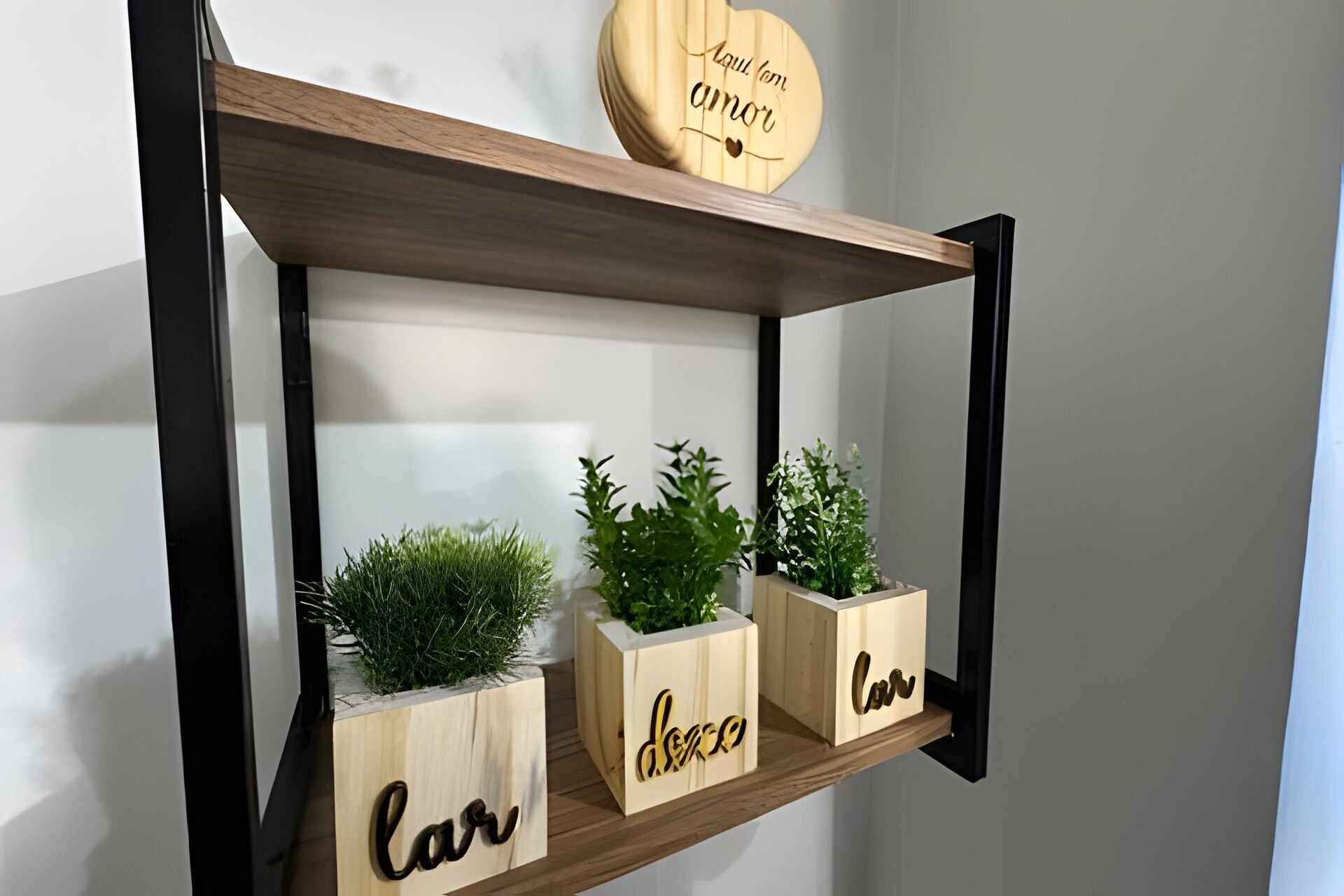 A wooden shelf with three planters, each with a name carved into it.