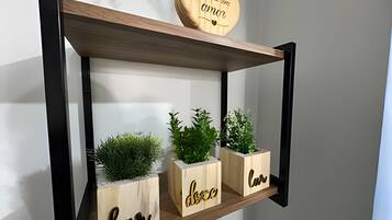 A wooden shelf with three planters, each with a name carved into it.