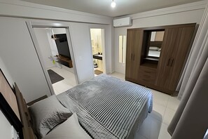 Ein Schlafzimmer mit Bett, Kleiderschrank, Bad und einer Küchenzeile.