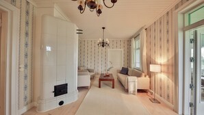 Ein großzügiger Wohnraum mit Kamin, zwei Sofas, einem Couchtisch und einer Kristallleuchtre.