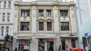 En historisk bygning med store vinduer og en central indgang.