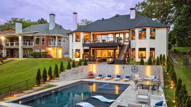 A large house with a swimming pool, outdoor seating, and a well-lit patio area. - Lakefront Luxury w/Private Heated Pool & Dock (Hot Springs)