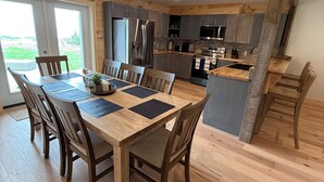 Una cocina moderna con armarios de madera, un refrigerador de acero inoxidable y un horno empotrado.