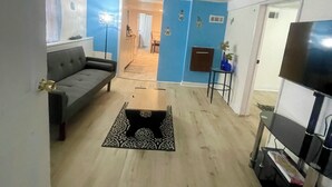 A living room with a sofa, a coffee table, and a TV stand. - Lower level luxury (Chicago)