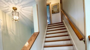 A staircase with wooden steps and a wooden handrail, leading to a door at the top.