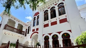 A white building with red accents, featuring arched windows and balconies. - Andara Hotel (Lima)