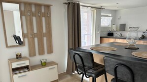Una cocina moderna con una isla central, taburetes de bar y una mesa de comedor.