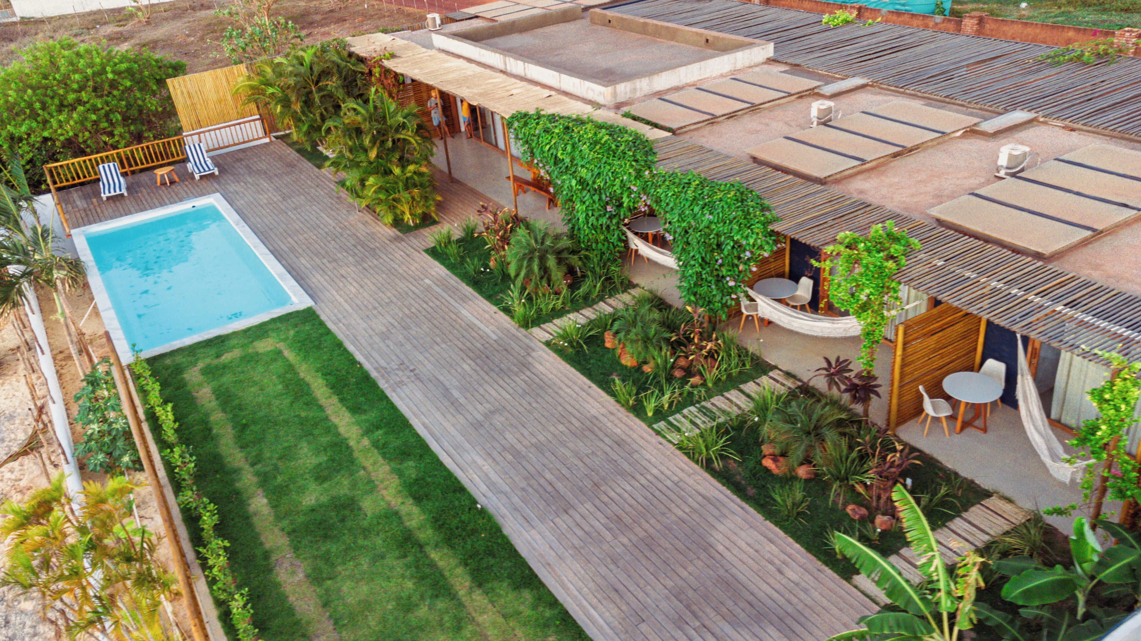 A rooftop pool area with a swimming pool, wooden deck, and various seating arrangements.