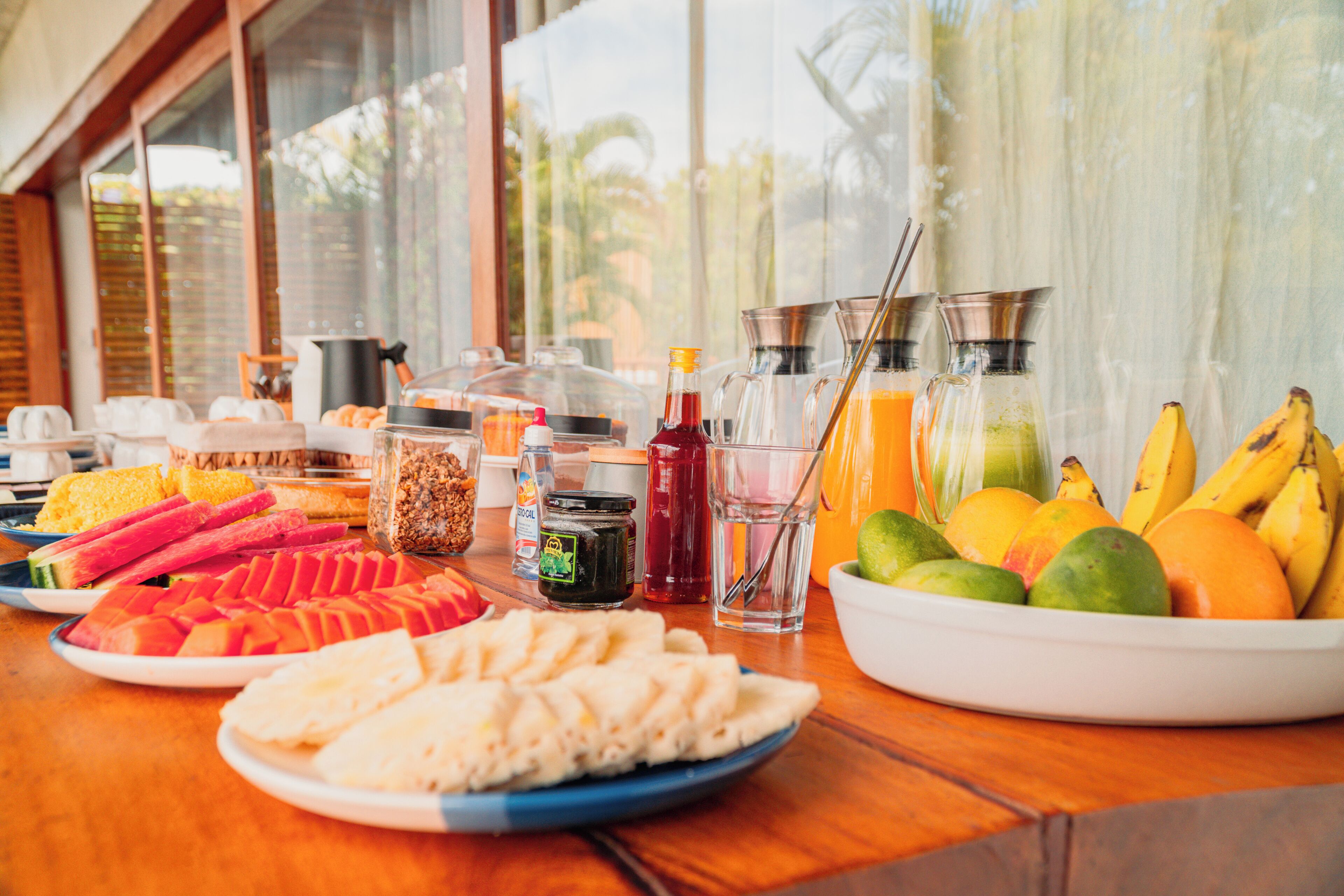 Un bufé de desayuno con diversas frutas, jugos y aderezos.