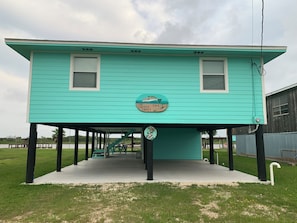 Une maison turquoise avec une enseigne sur laquelle on peut lire : « The Trusty Trou ».