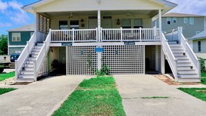 A two-story building with a covered front porch and a garage.