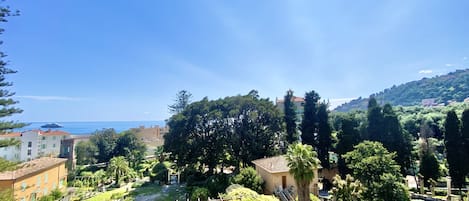 A coastal landscape with buildings, trees, and a clear sky.