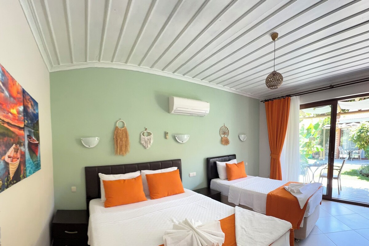 Une chambre d’hôtel avec deux lits, un ventilateur de plafond, un appareil de climatisation et une vue sur l’espace extérieur.