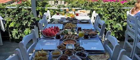 An outdoor dining area with a table set for a meal, overlooking a scenic landscape.