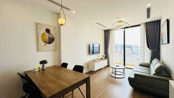 Apartamento superluxo, 1 cama Queen, vista para a cidade | Área de estar | TV LED 55 polegadas com canais a cabo